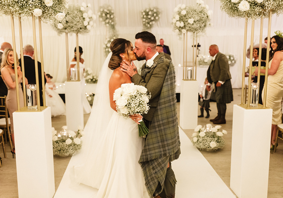 Bride and groom kiss at the altar